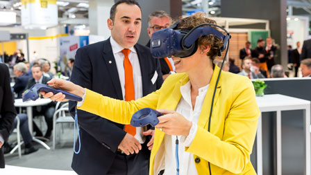 Foto einer Frau mit VR-Brille auf dem Messestand